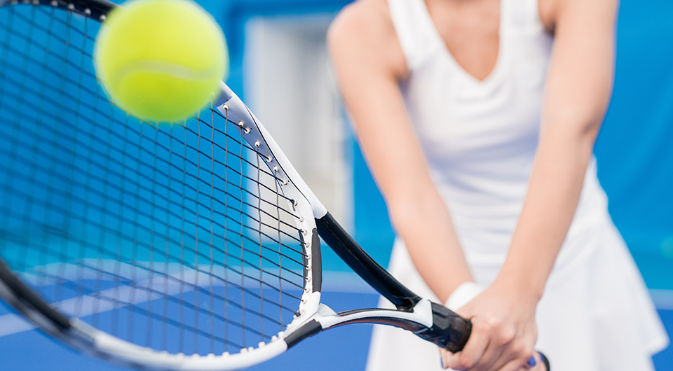 a woman holding a tennis racket and a ball