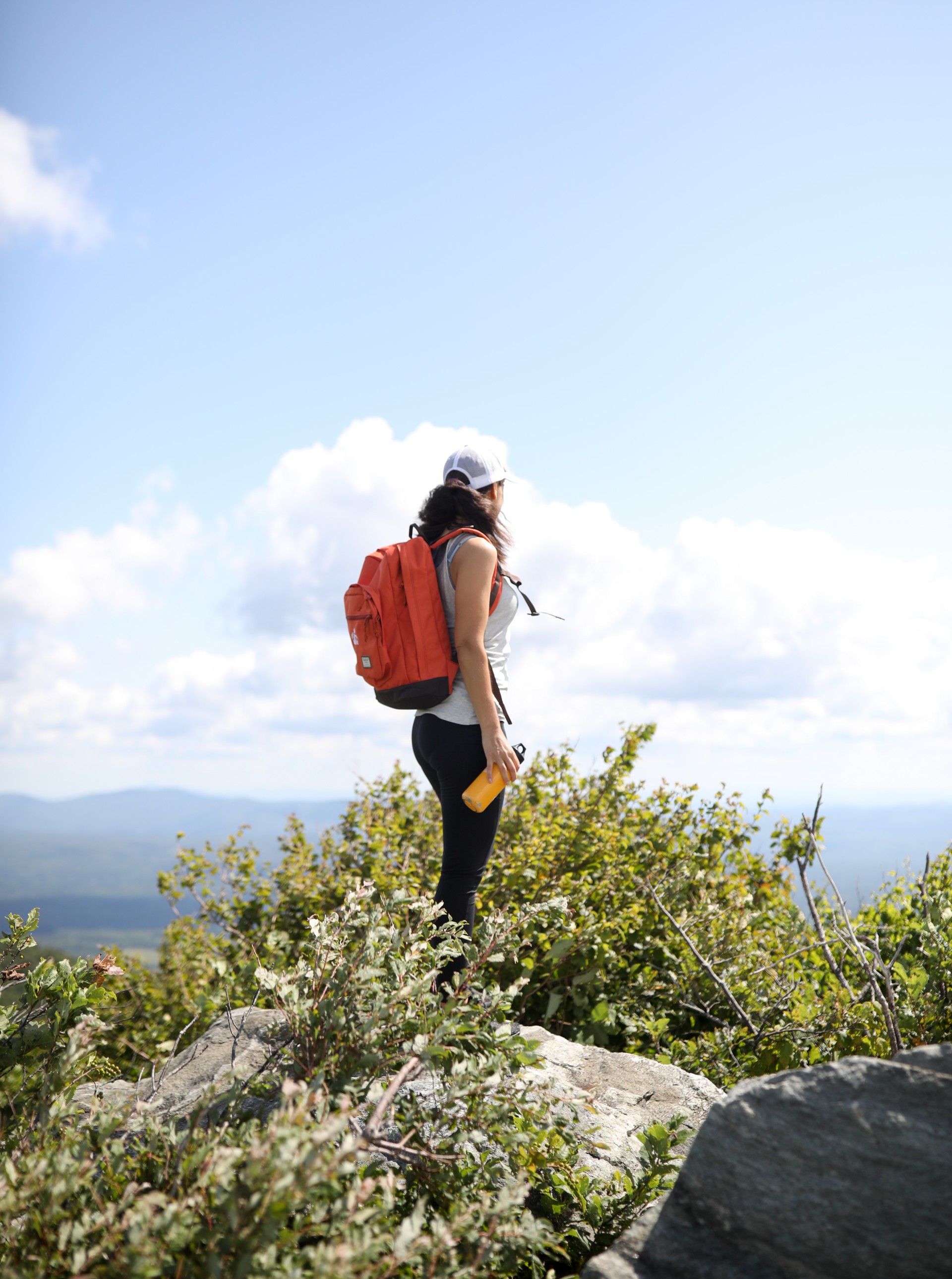 a woman with a backpack on a mountain