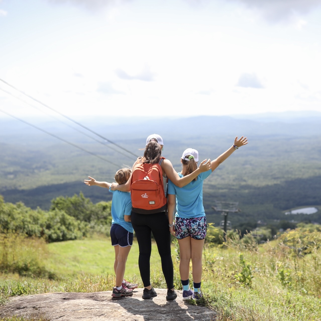 a group of people standing on a rock with arms outstretched