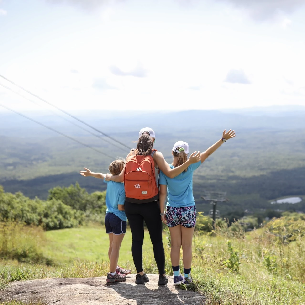 a group of people standing on a rock with arms outstretched