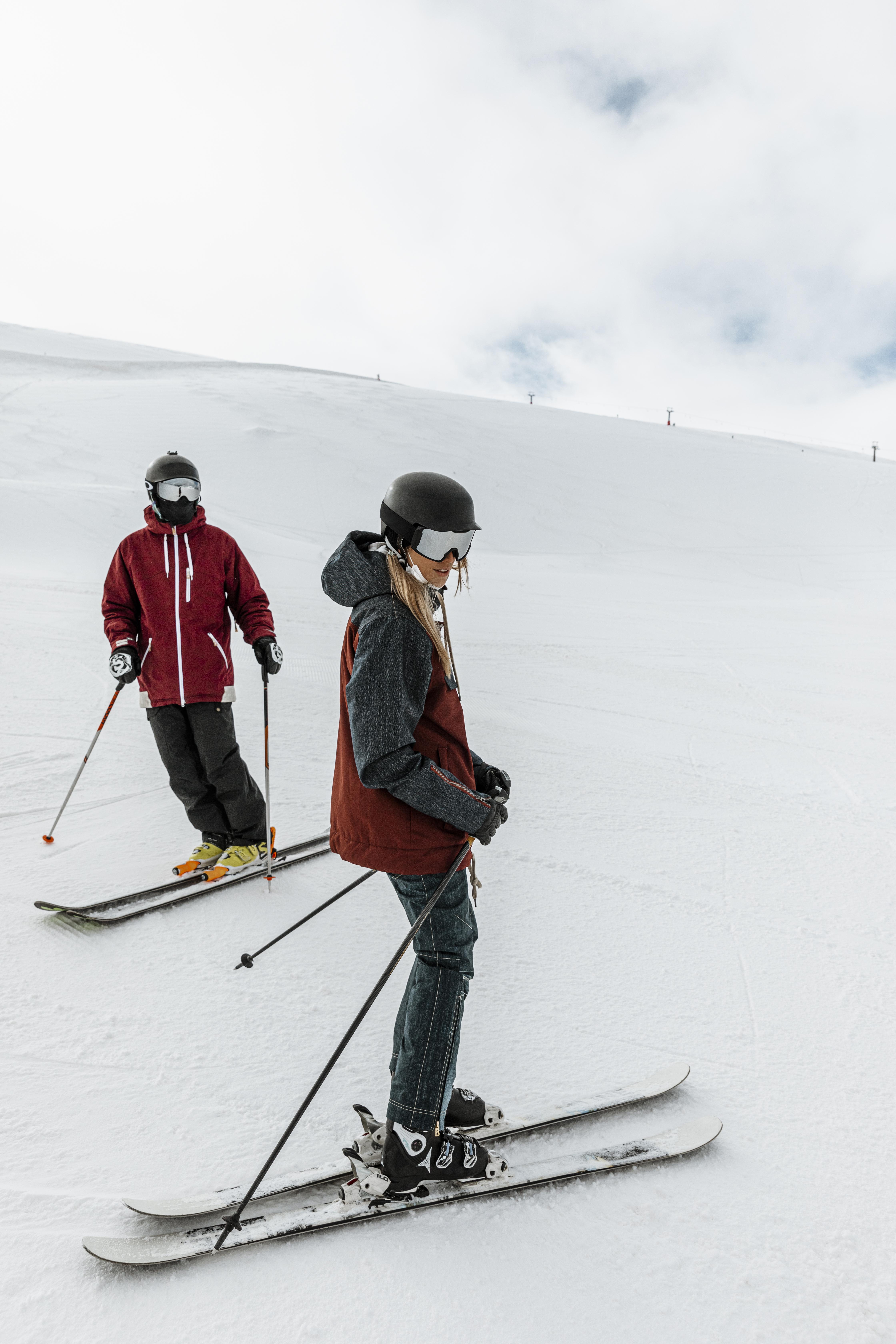 a couple of people skiing on a snowy hill