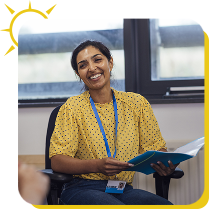 a woman smiling while holding a file
