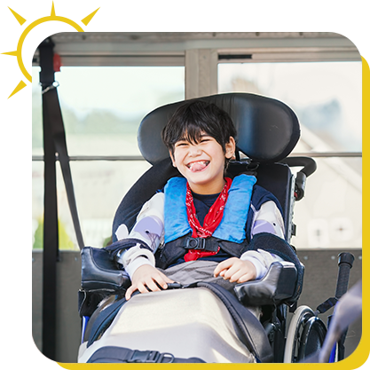a boy in a wheelchair sticking his tongue out