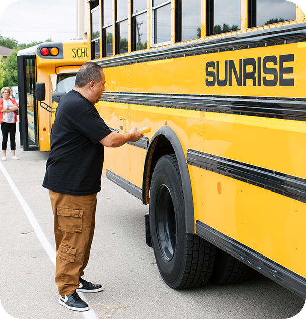 a man standing next to a yellow school bus