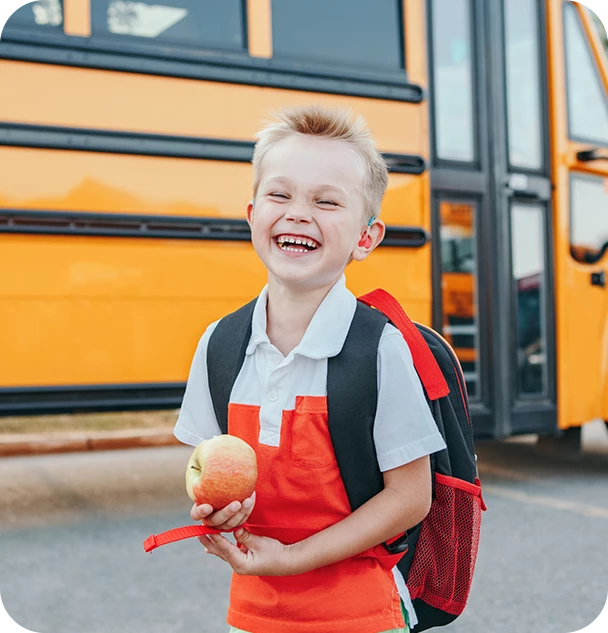 a boy holding an apple and smiling