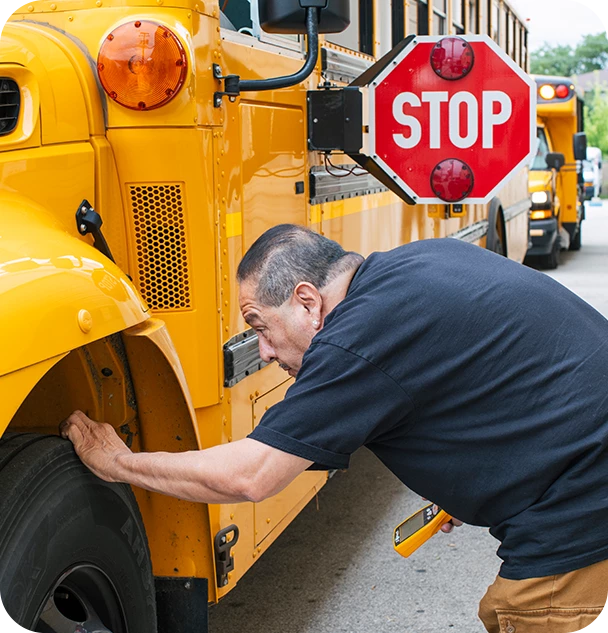 a man fixing a tire on a school bus