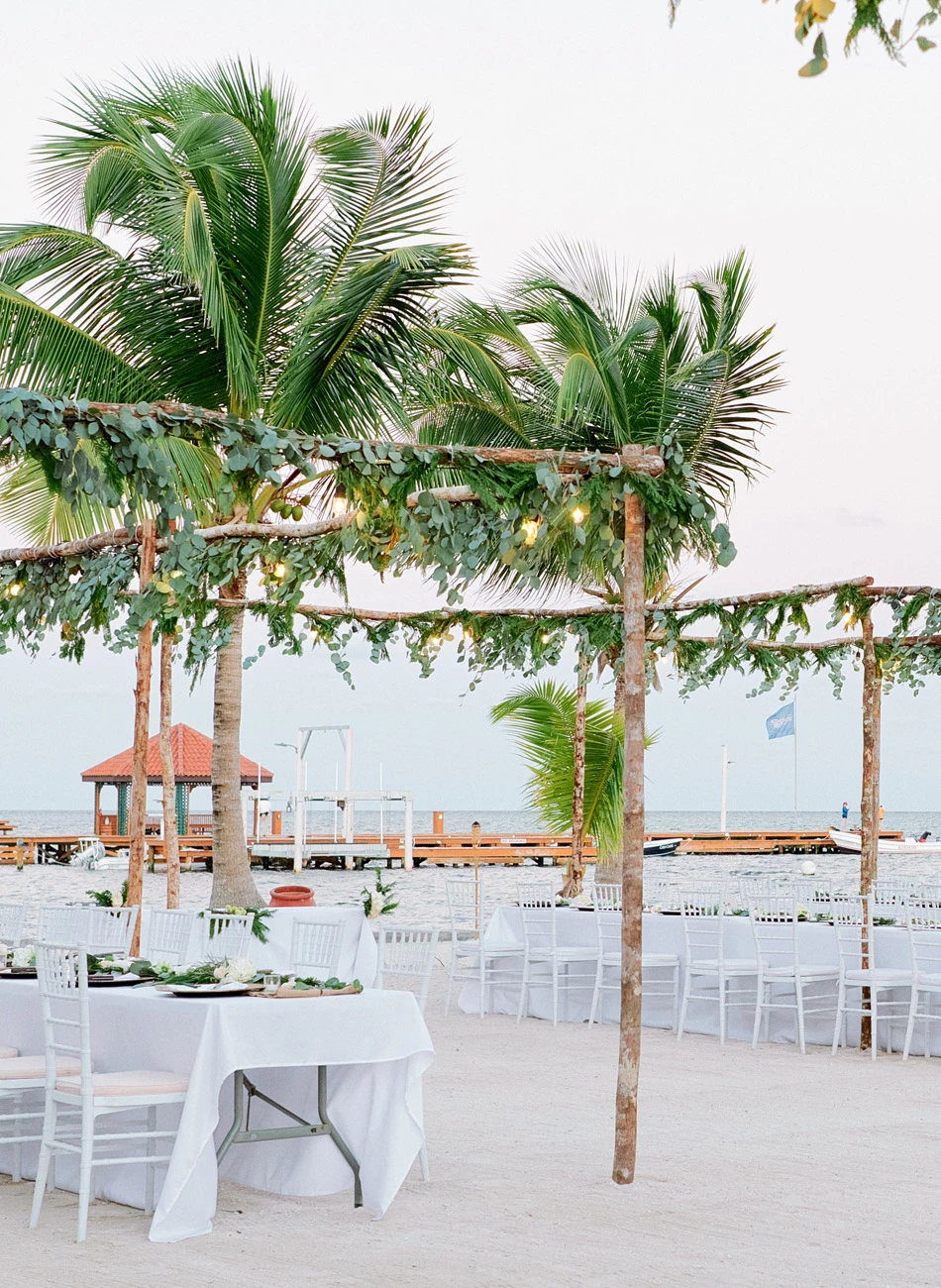 a beach with palm trees and tables