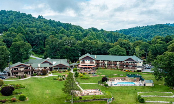 a group of buildings with a pool in front of trees