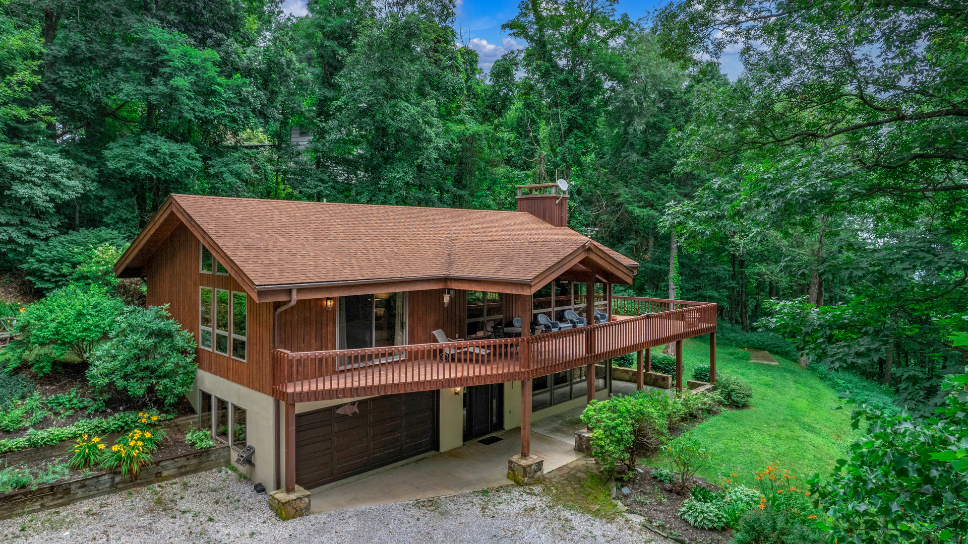 a house with a deck and a yard with trees in the background