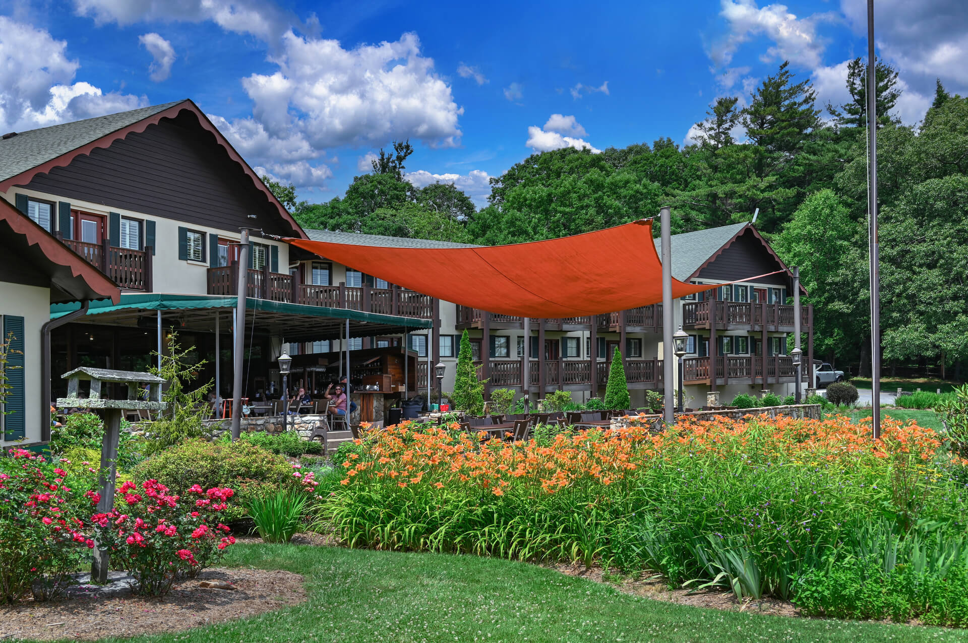 a garden with flowers and a red awning