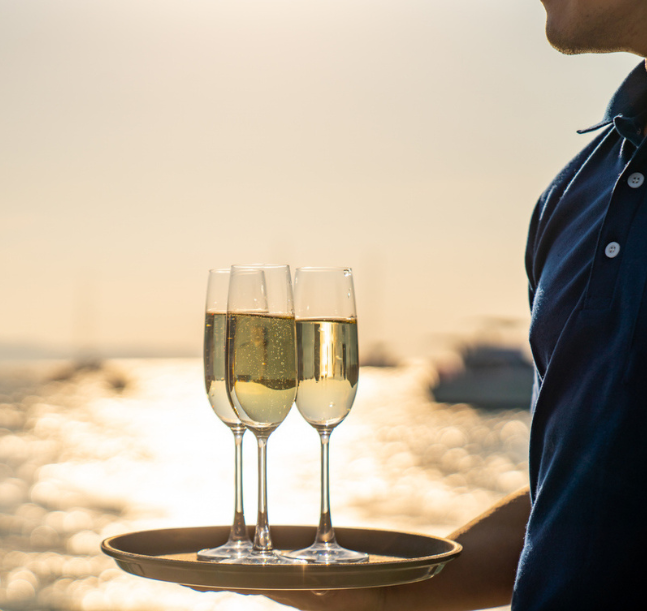 a man holding a tray with wine glasses
