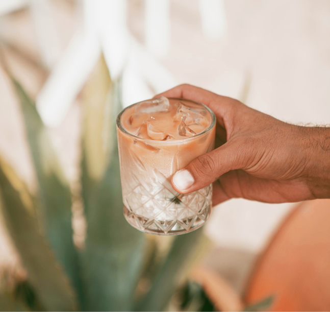 a hand holding a glass of ice