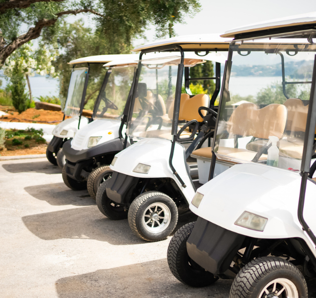 a group of golf carts parked on a road