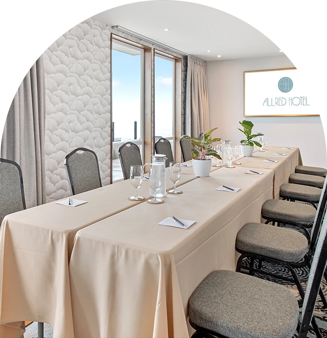 a long table with chairs and a table with a white tablecloth