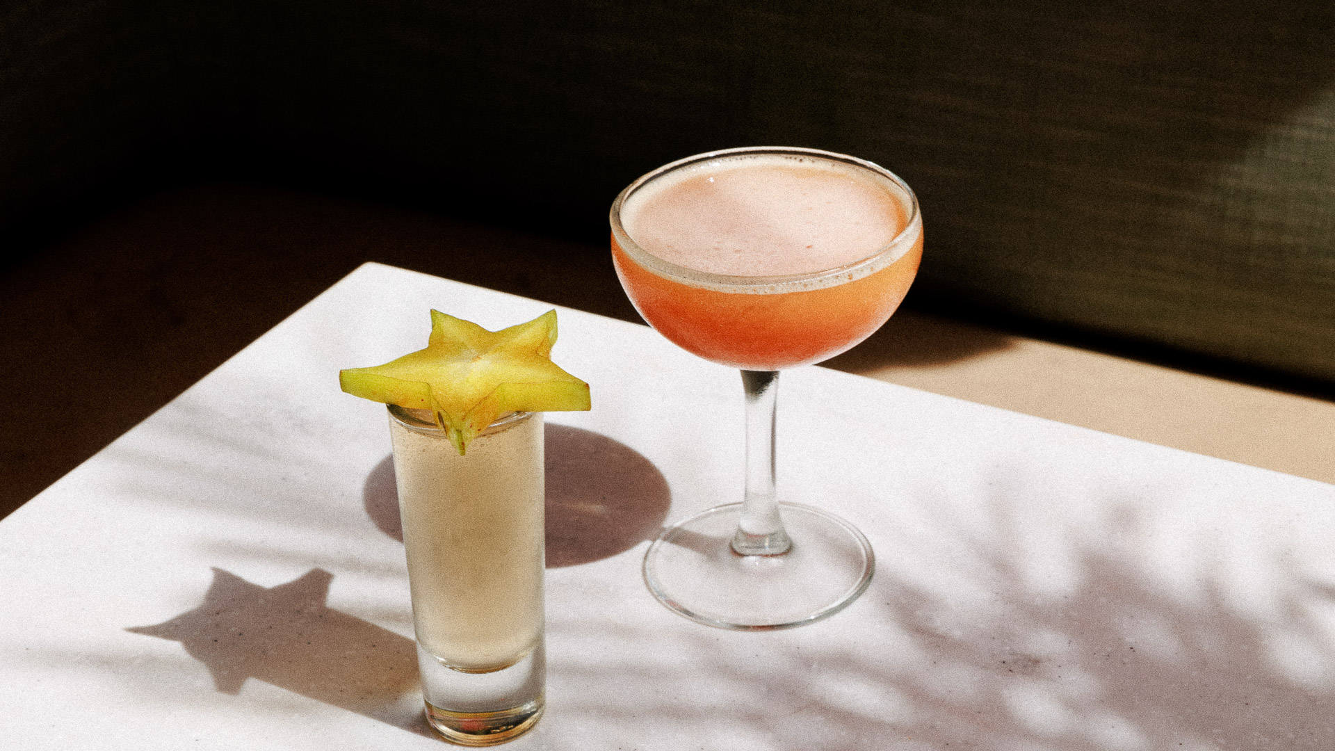 two glasses with a star fruit on the side