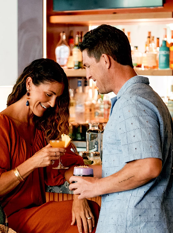 a man and woman holding drinks