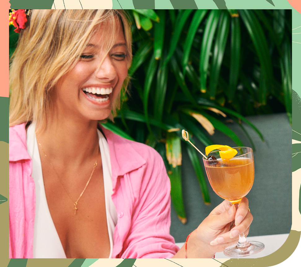 a woman smiling at a drink