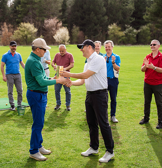 a group of men shaking hands on a golf course