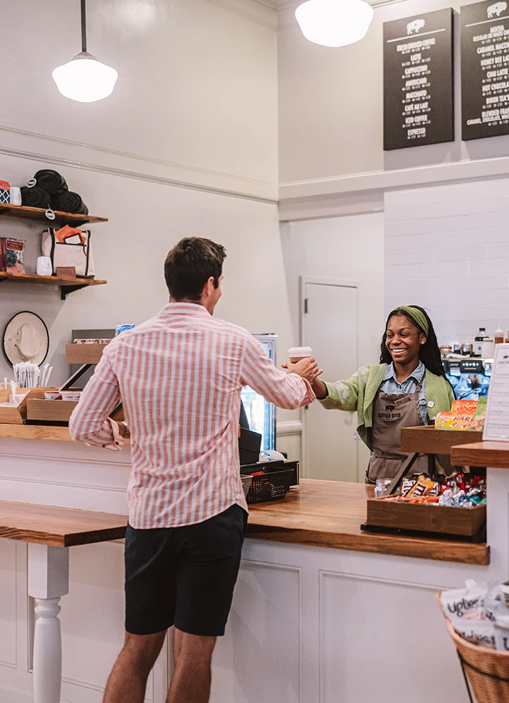 a man and woman shaking hands in a coffee shop