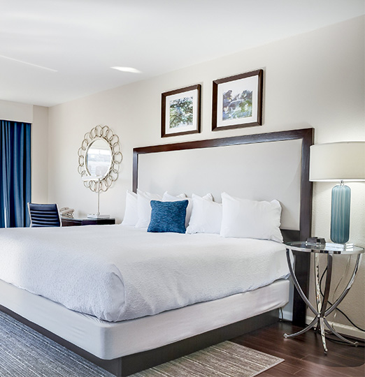 a bed with a white bed frame and blue curtains