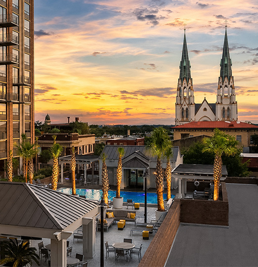a rooftop view of a building with palm trees and a pool
