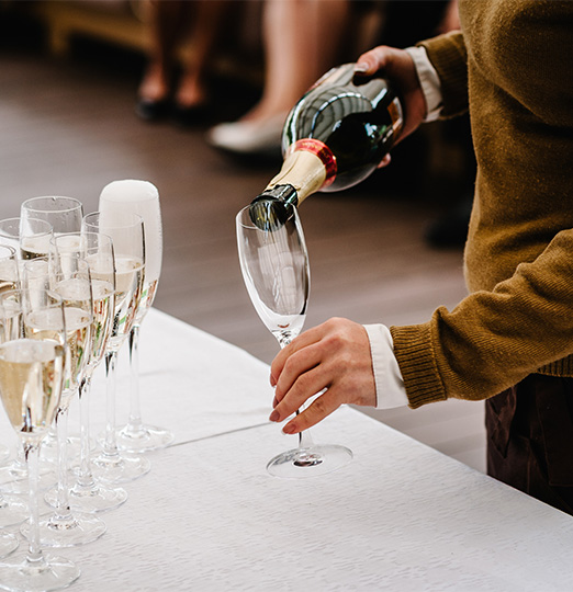 a person pouring champagne into a glass