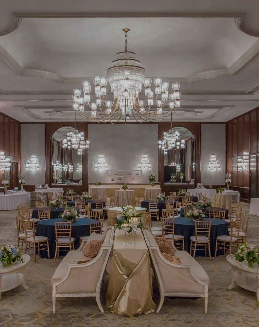 a room with tables and chairs and chandeliers