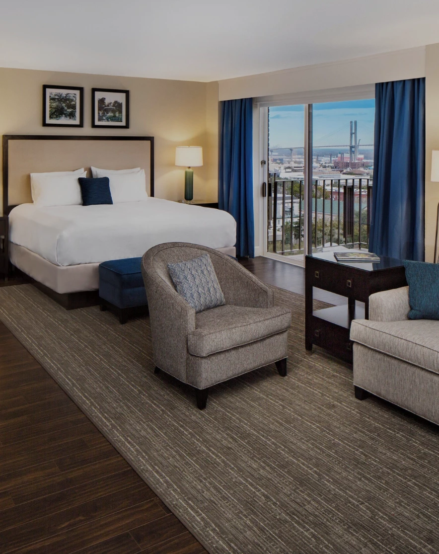 a room with a bed and chairs