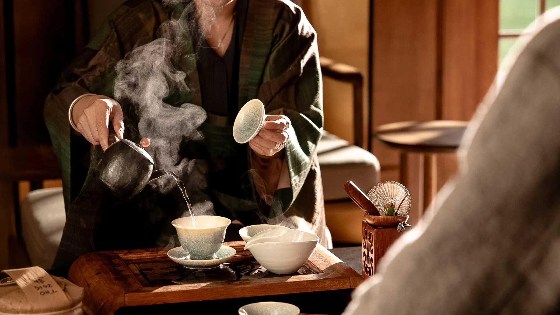 a person pouring tea into cups