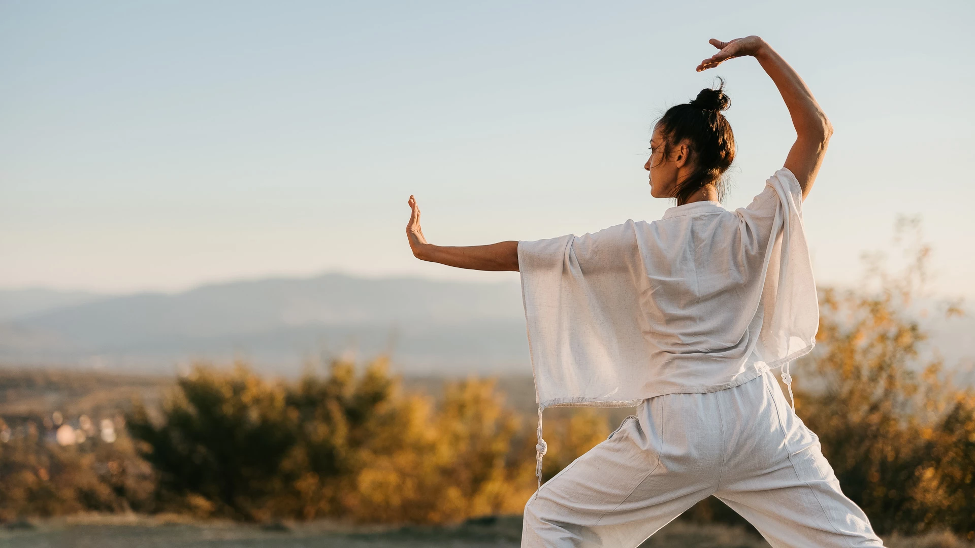 a woman in white clothes with arms outstretched