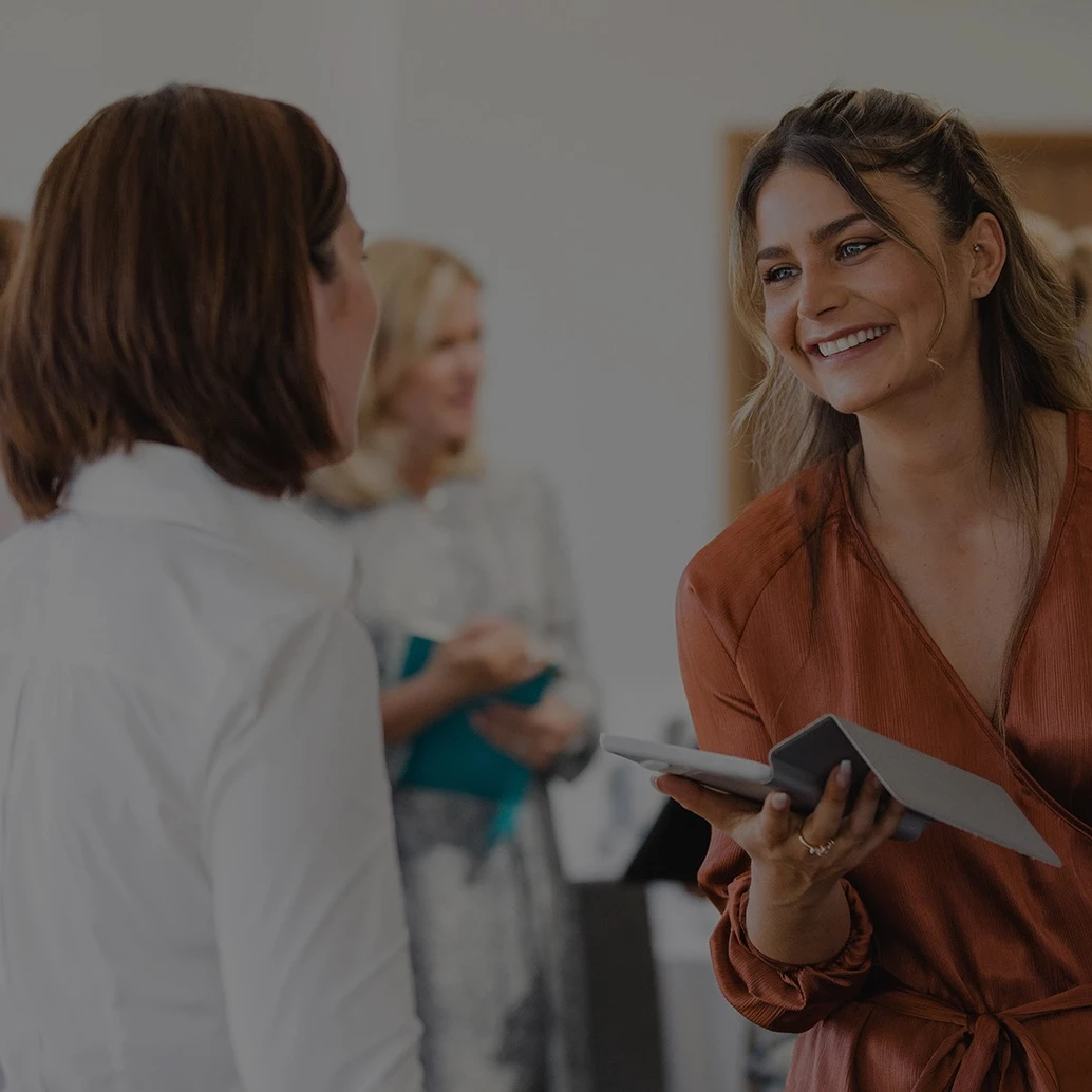 a woman holding a tablet and smiling