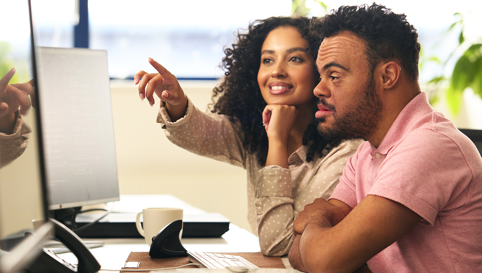 a man and woman looking at a computer screen