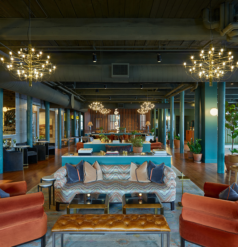 a room with a large living room with a large chandelier and couches