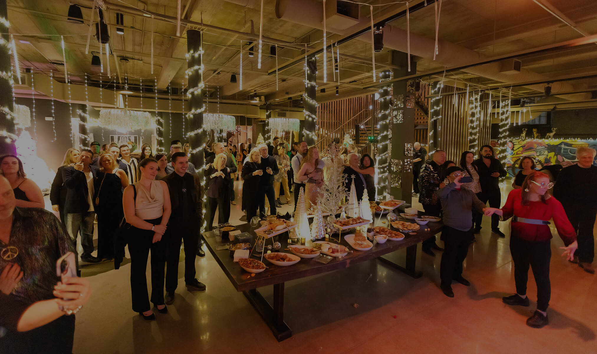 a group of people standing around a table full of food
