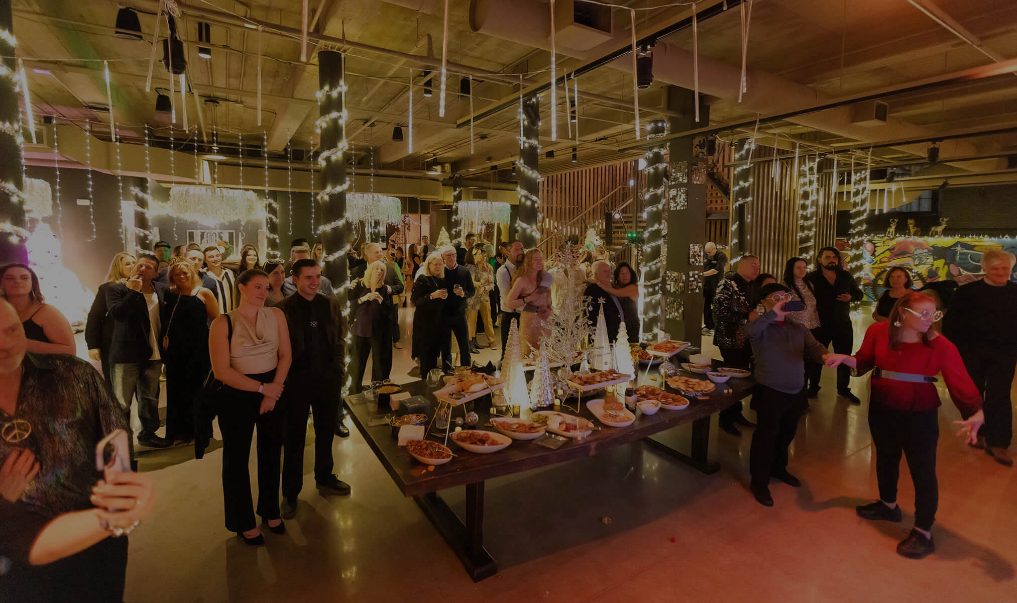 a group of people standing around a table full of food