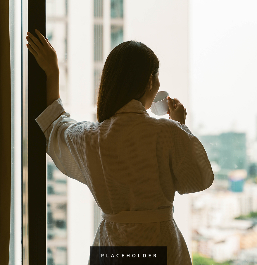 a woman in a robe drinking from a cup