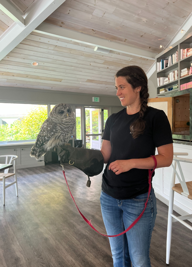a woman holding an owl on a leash