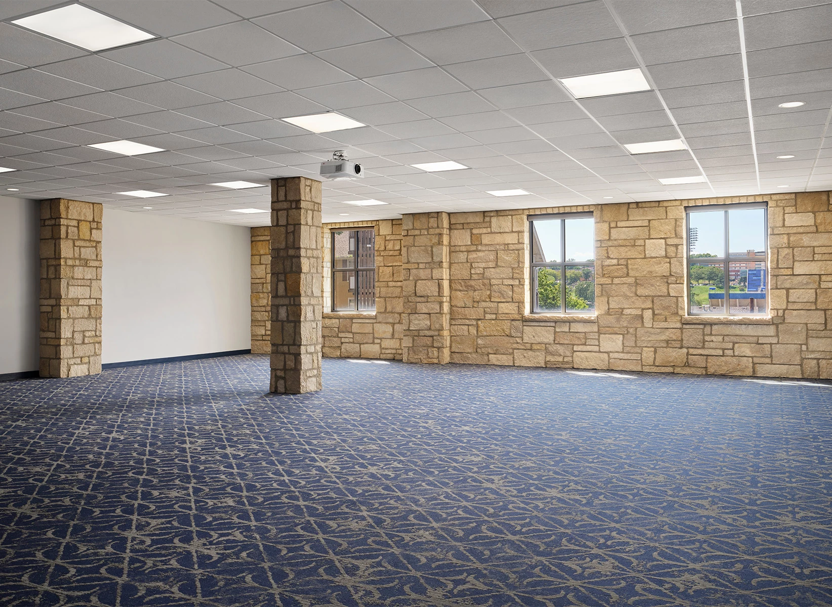a room with stone pillars and blue carpet