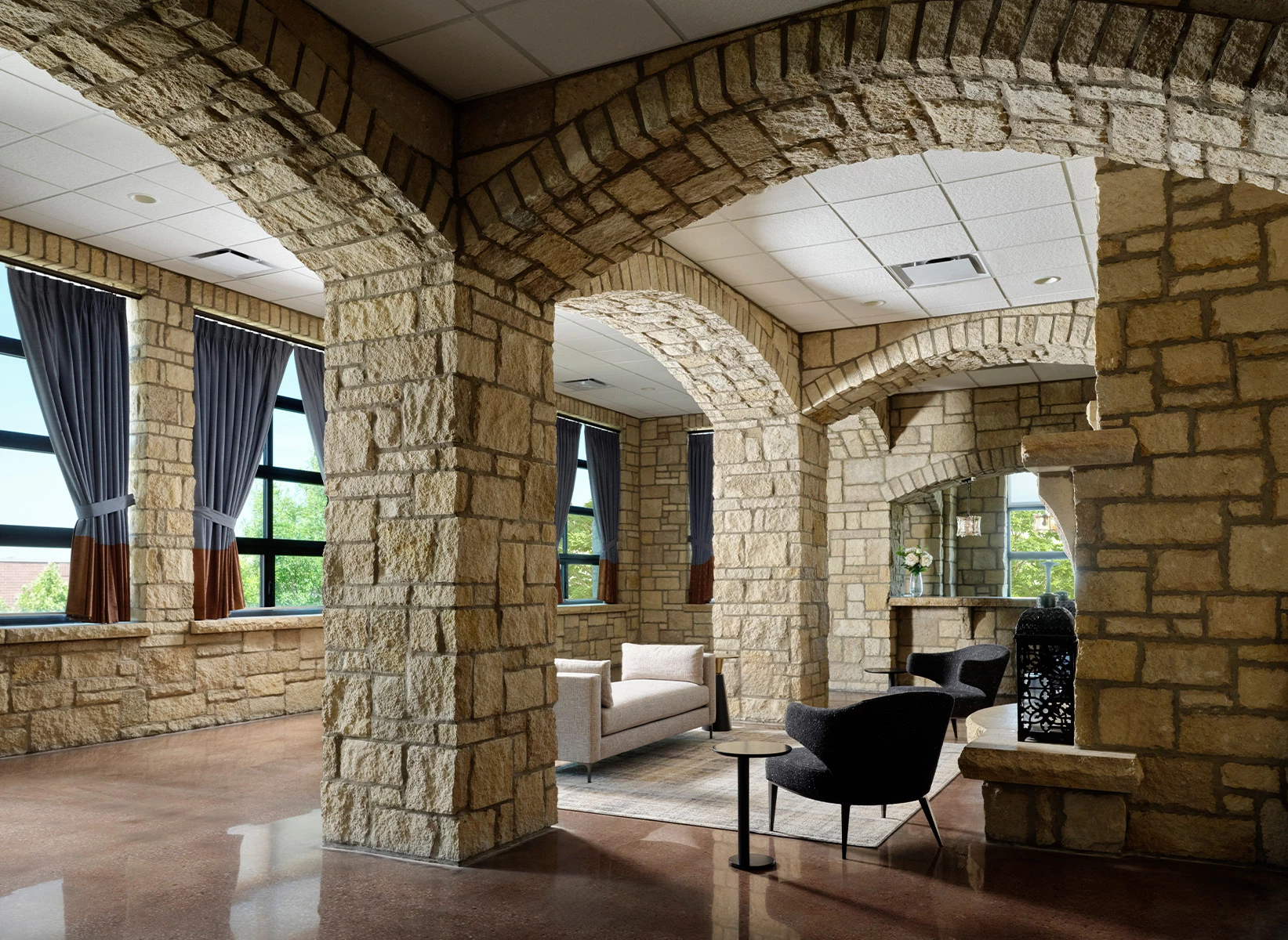 a stone room with a couch and chairs