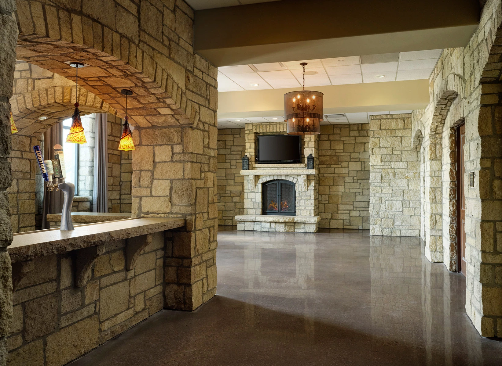 a stone room with a fireplace and a bar
