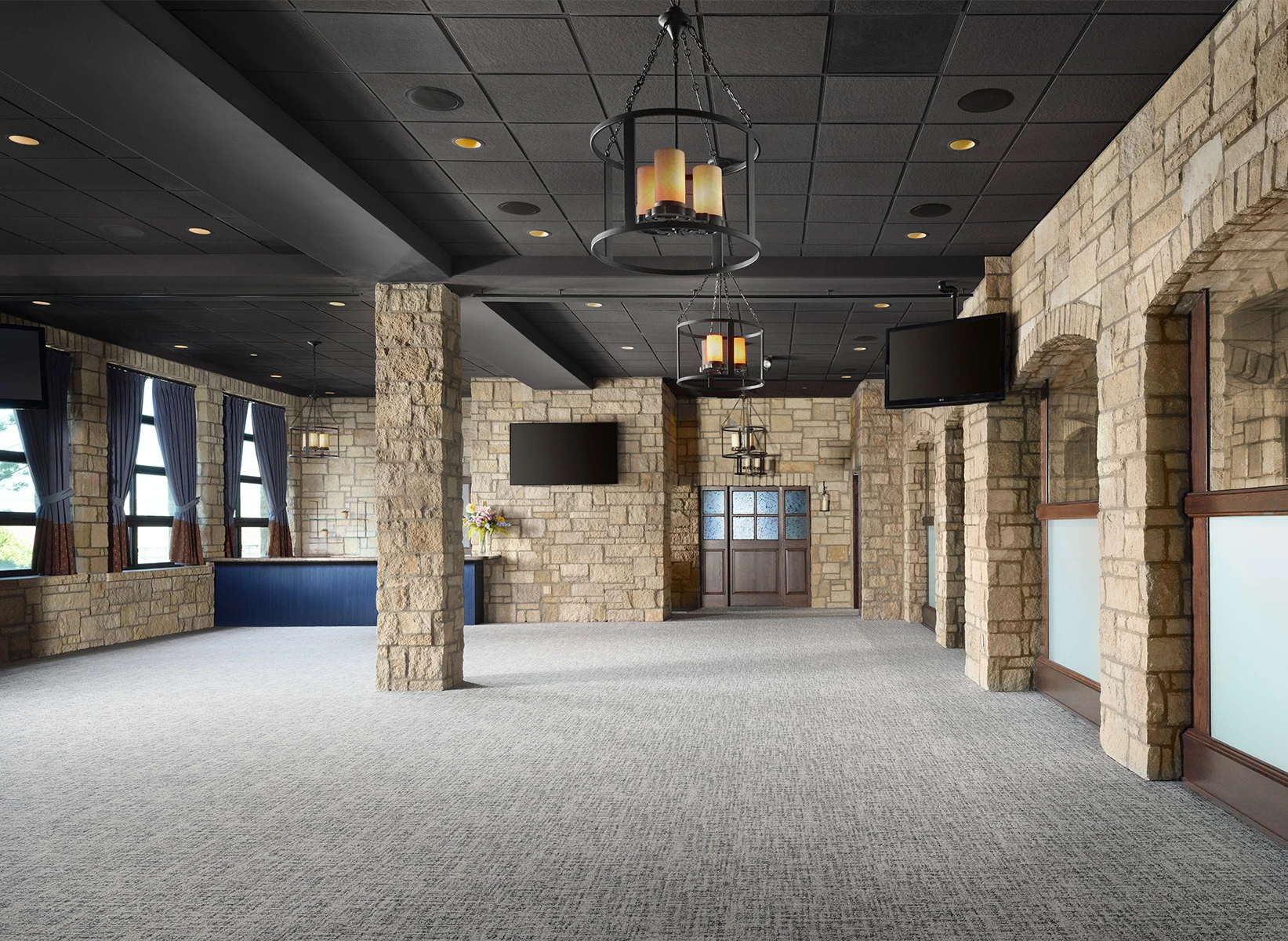 a large room with stone pillars and a television