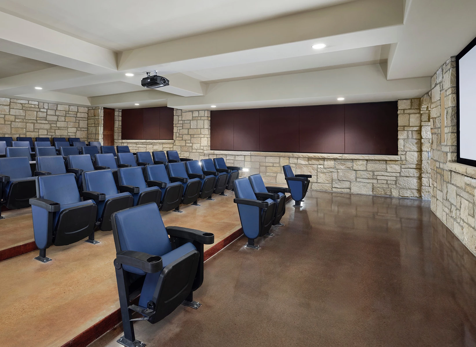a room with blue chairs and a stone wall