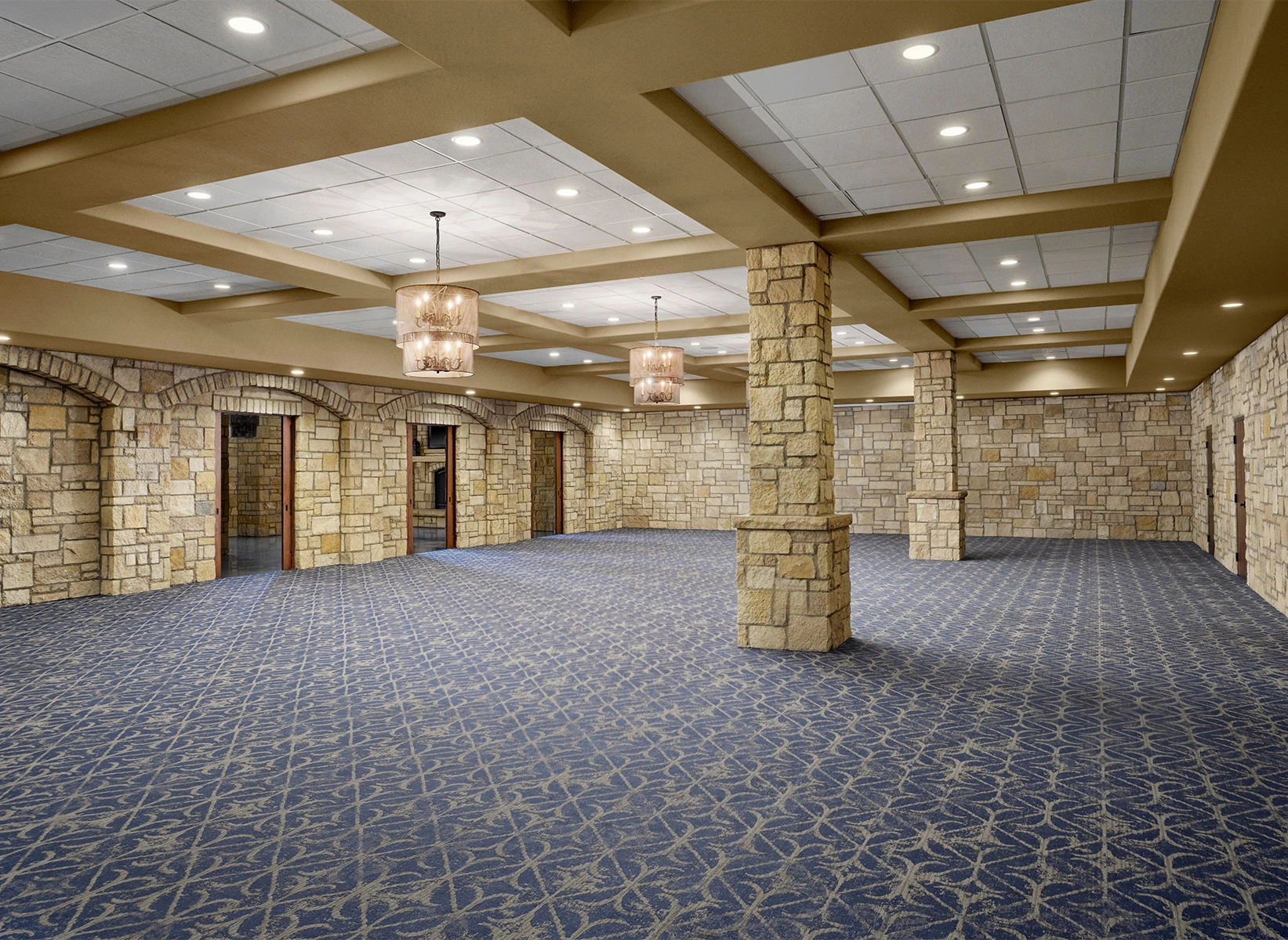 a large room with stone pillars and blue carpet
