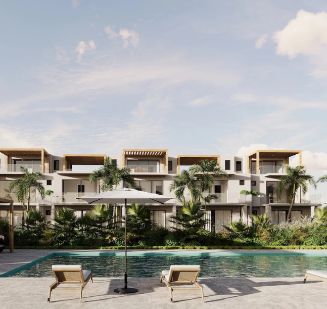 a pool with lounge chairs and palm trees in front of a building