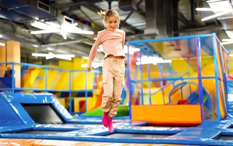 a girl jumping on a trampoline