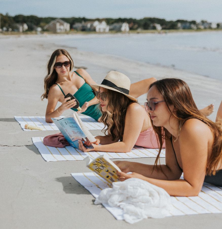 a group of women lying on the beach