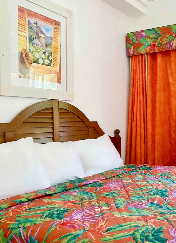a bed with a colorful bedding and a framed picture on the wall