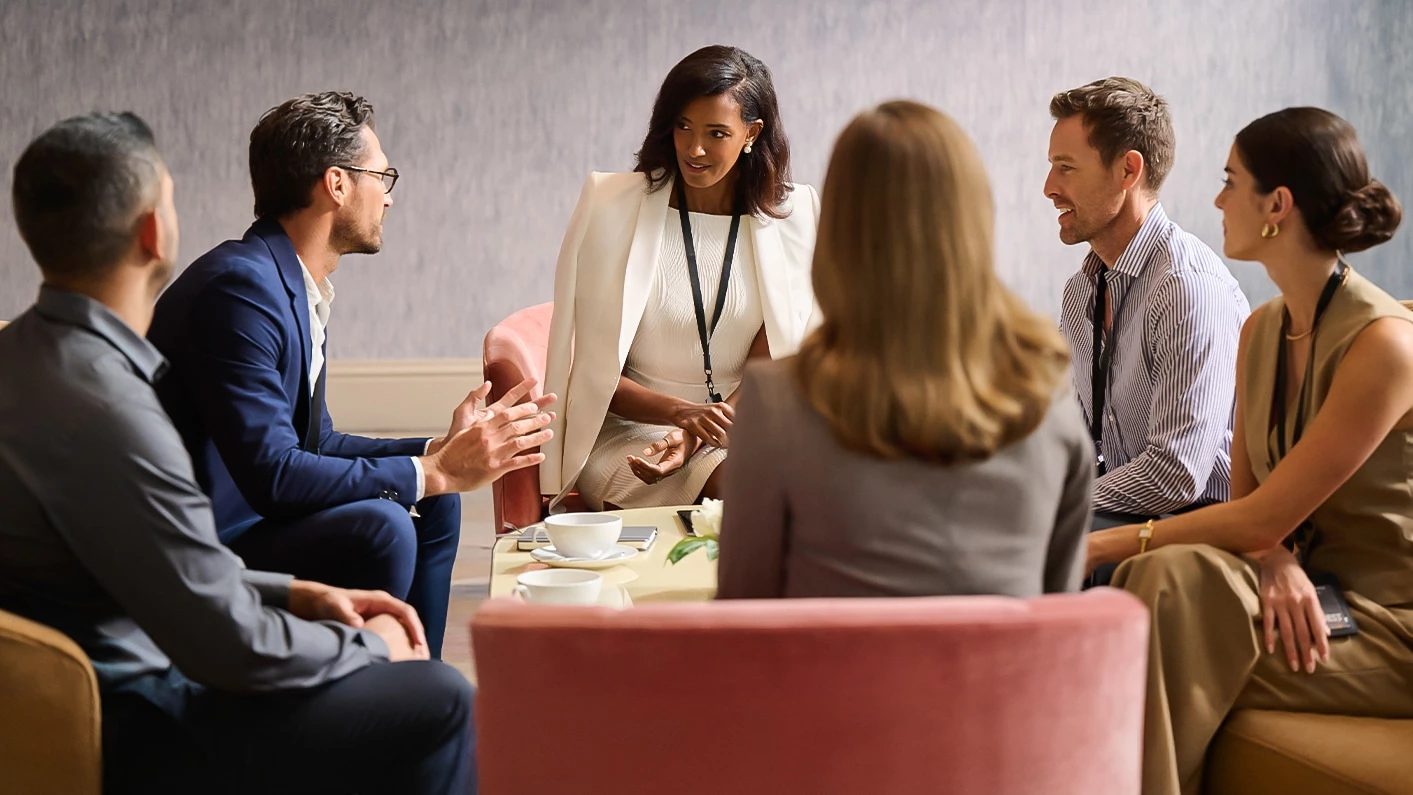 a group of people sitting around a table talking