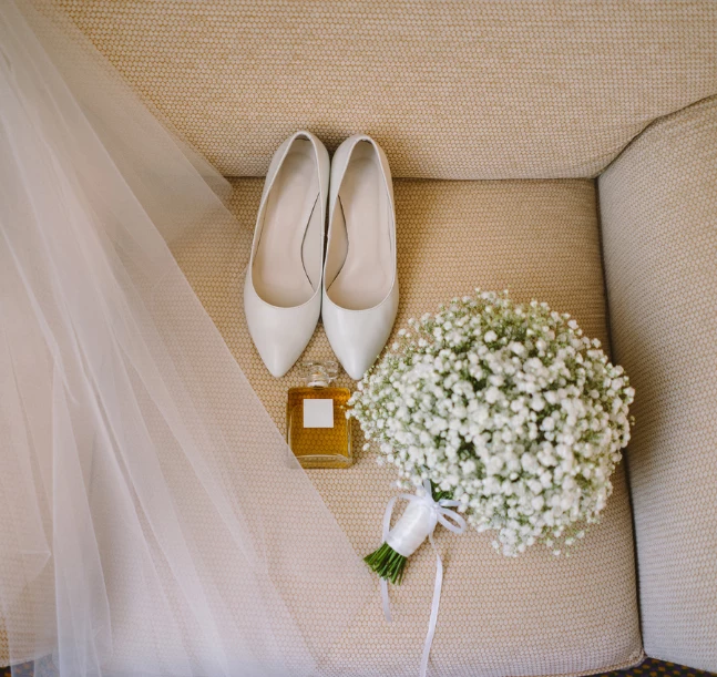 a bridal bouquet and shoes on a couch