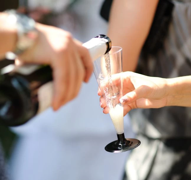 a person pouring champagne into a glass